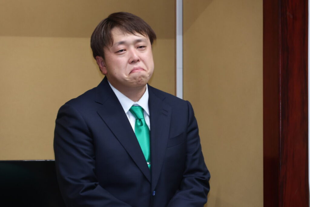 涙をこらえて話す齋藤氏