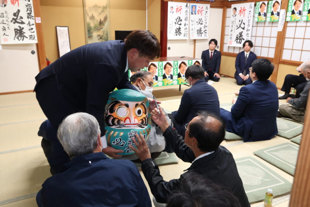 参加者全員でだるまの目入れ