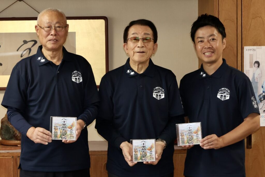 CD「八十里越天空大橋」を手に左から西けんじさん、長橋正宣さん、滝沢亮市長